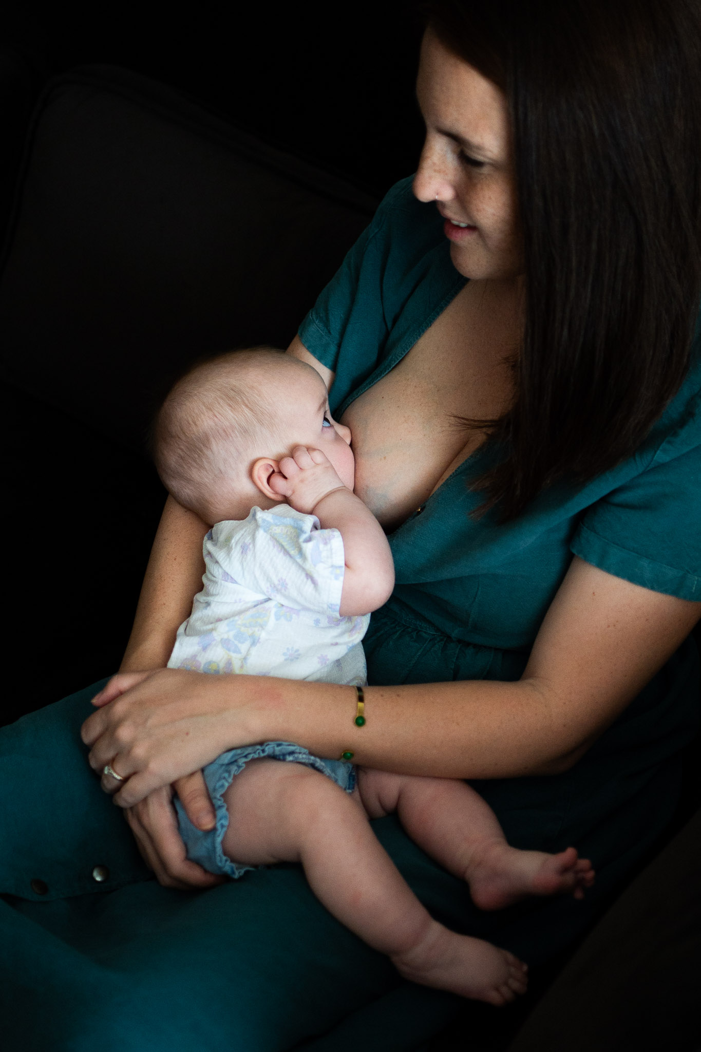un maman allaite son bébé lors d'une séance à domicile