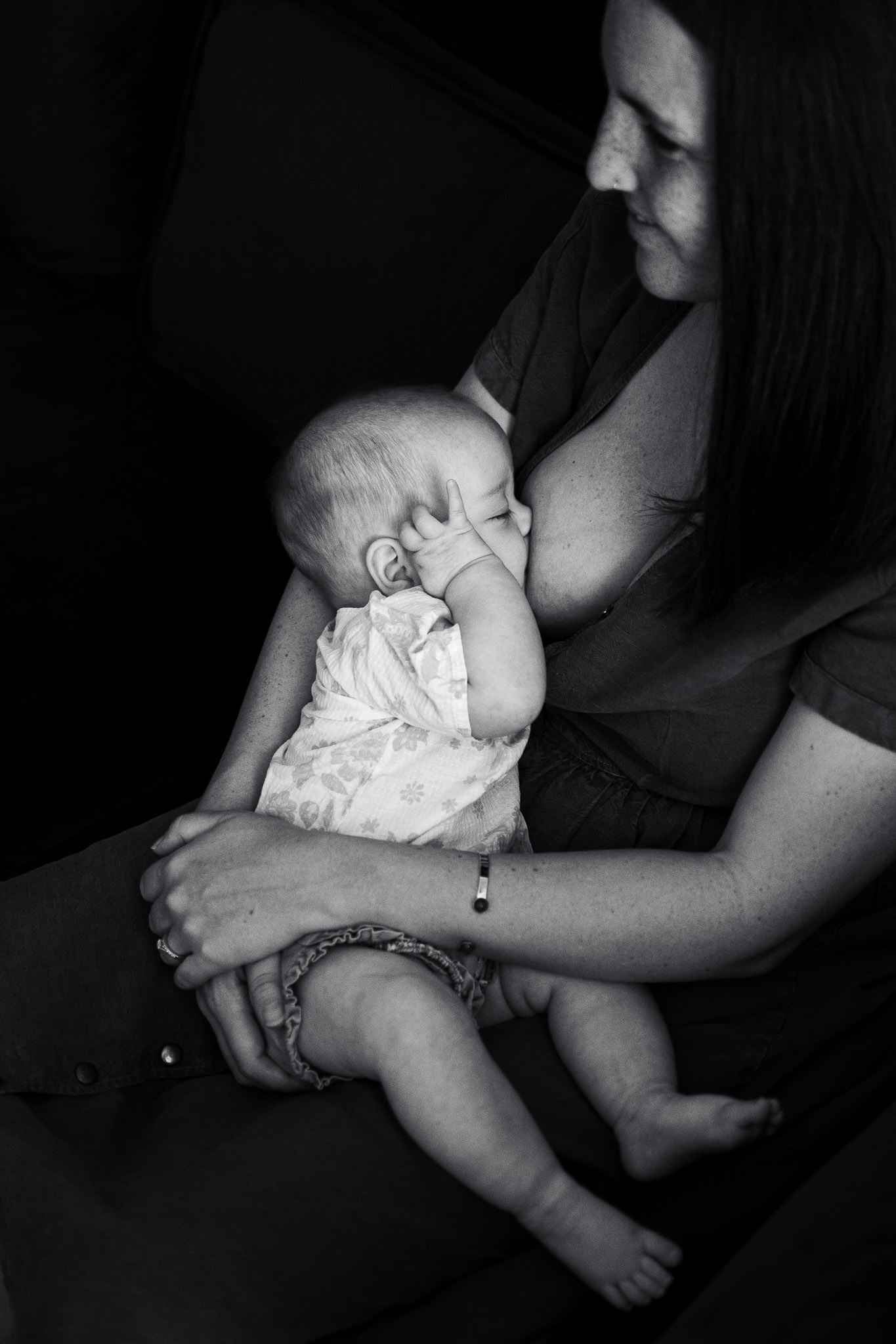 un bébé tète, photo en noir et blanc