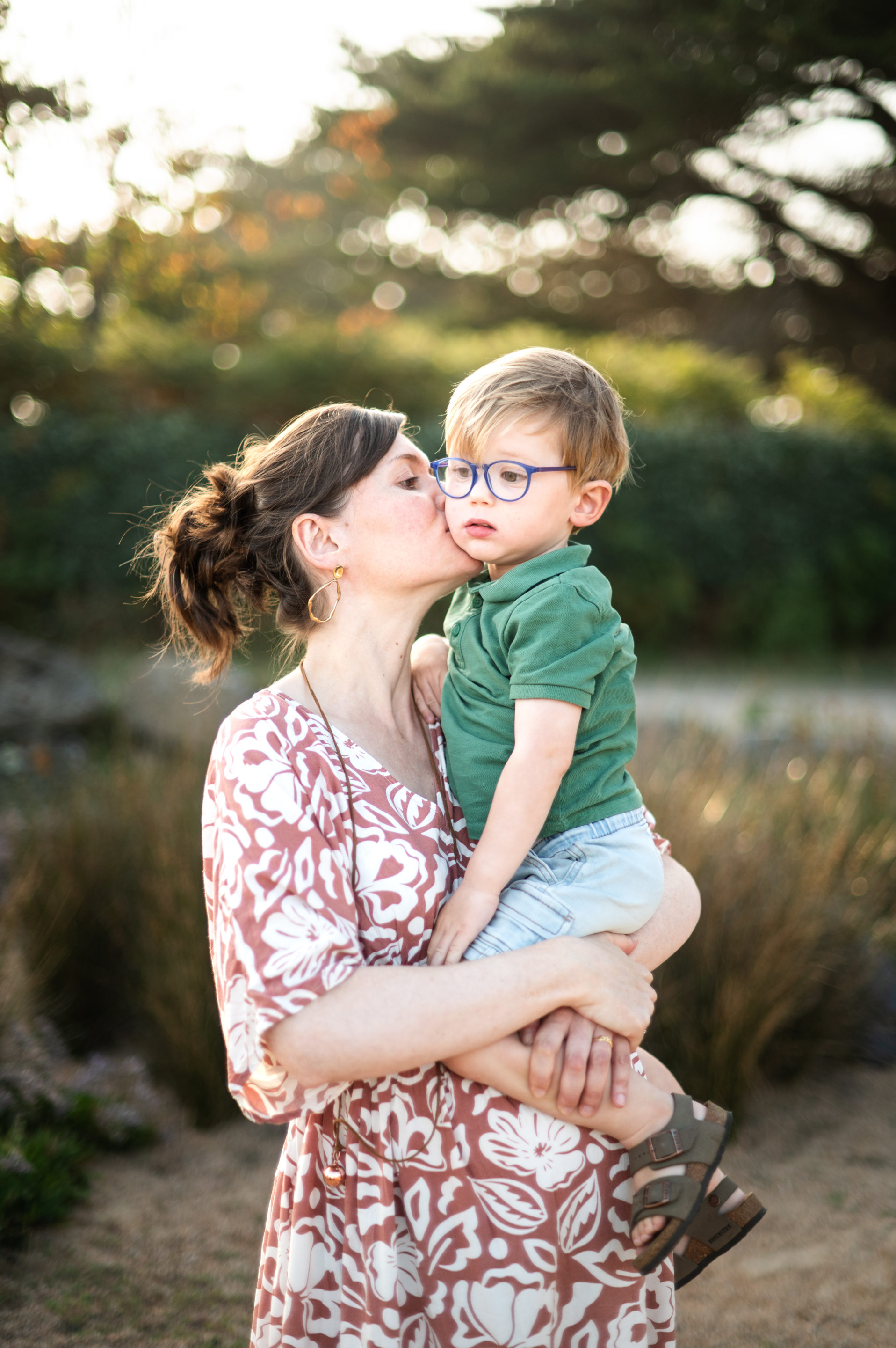 Seance-grossesse-famille-cotes-darmor une maman embrasse son fils lors d'une séance grossesse dans les cotes d'armor
